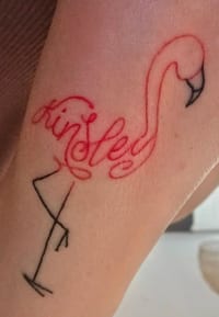 Flamingo tattoo with the name Kinsley in red calligraphy